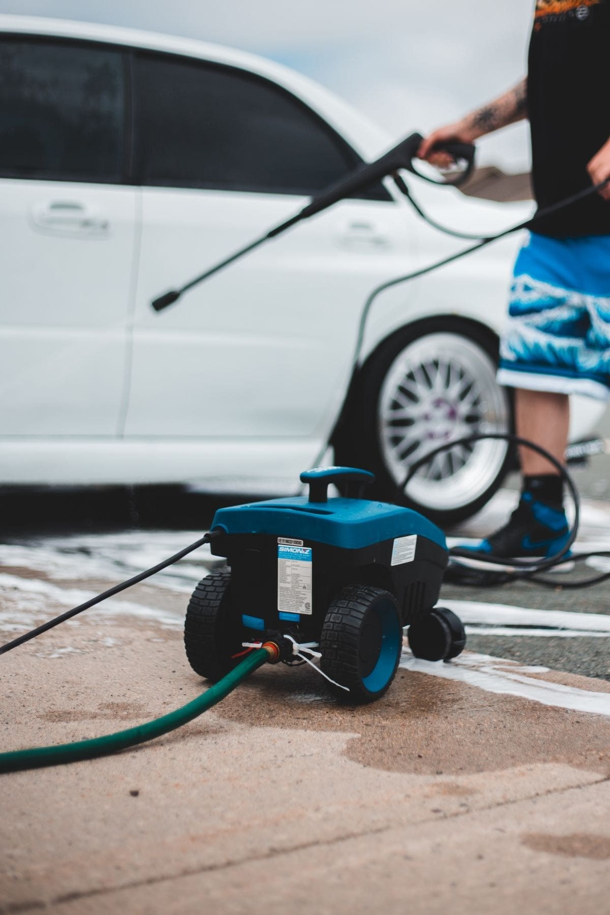 Stock photo: Pressure washer and hose on a paved driveway