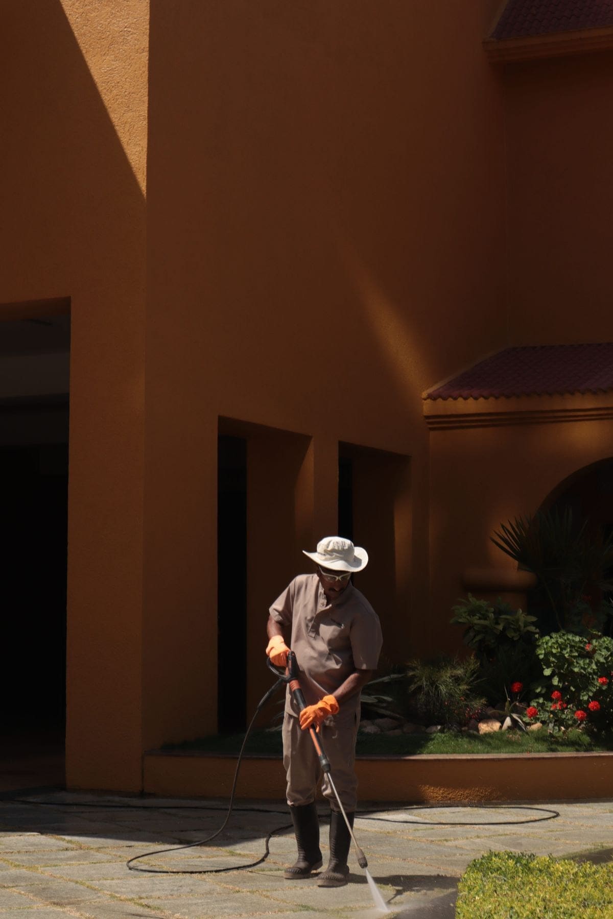 Stock photo: Worker pressure washing an exterior walkway